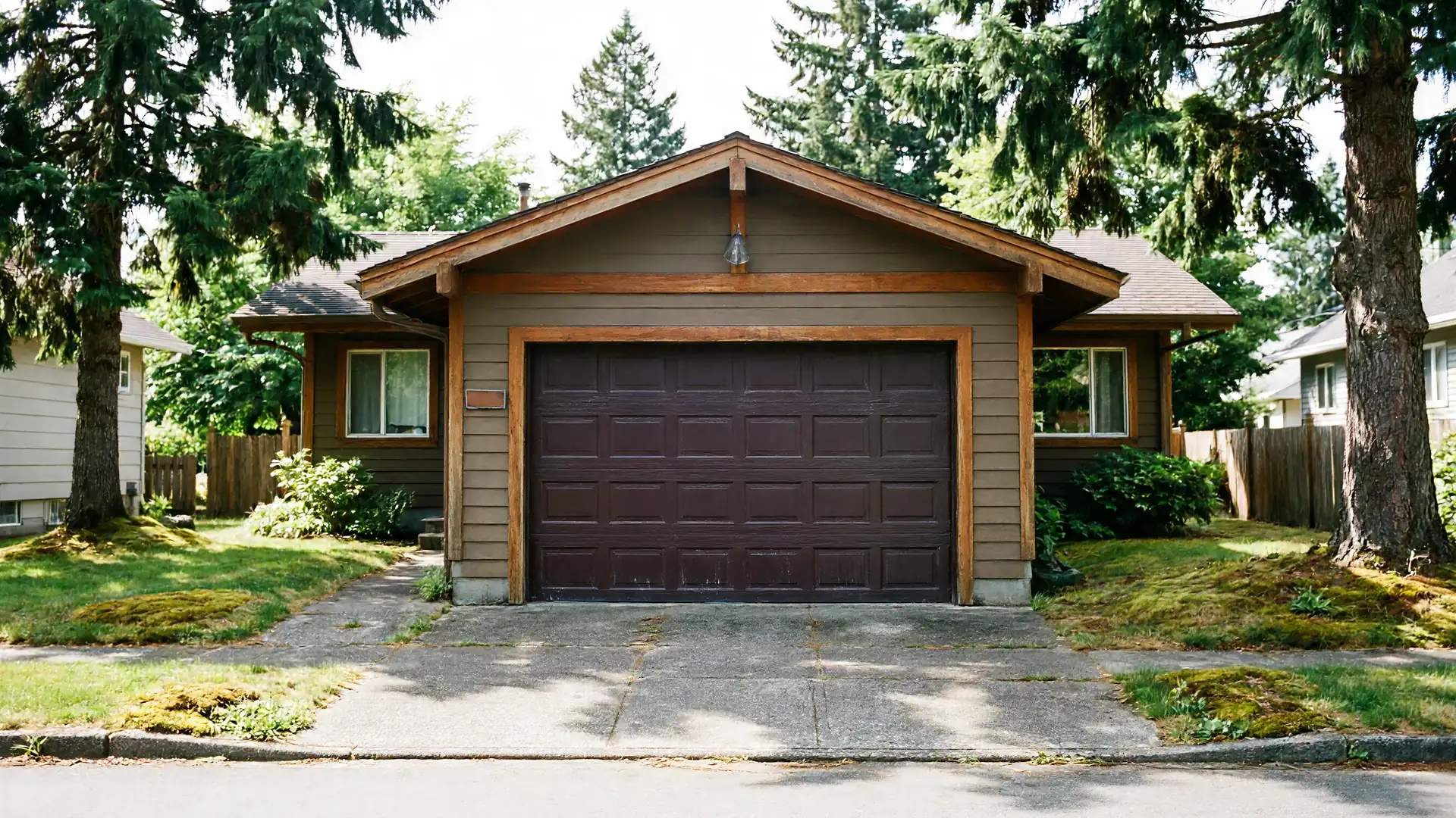 A brown house with a brown garage door and a concrete driveway.